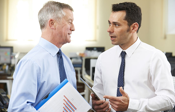 businessman having discussion with senior mentor in office