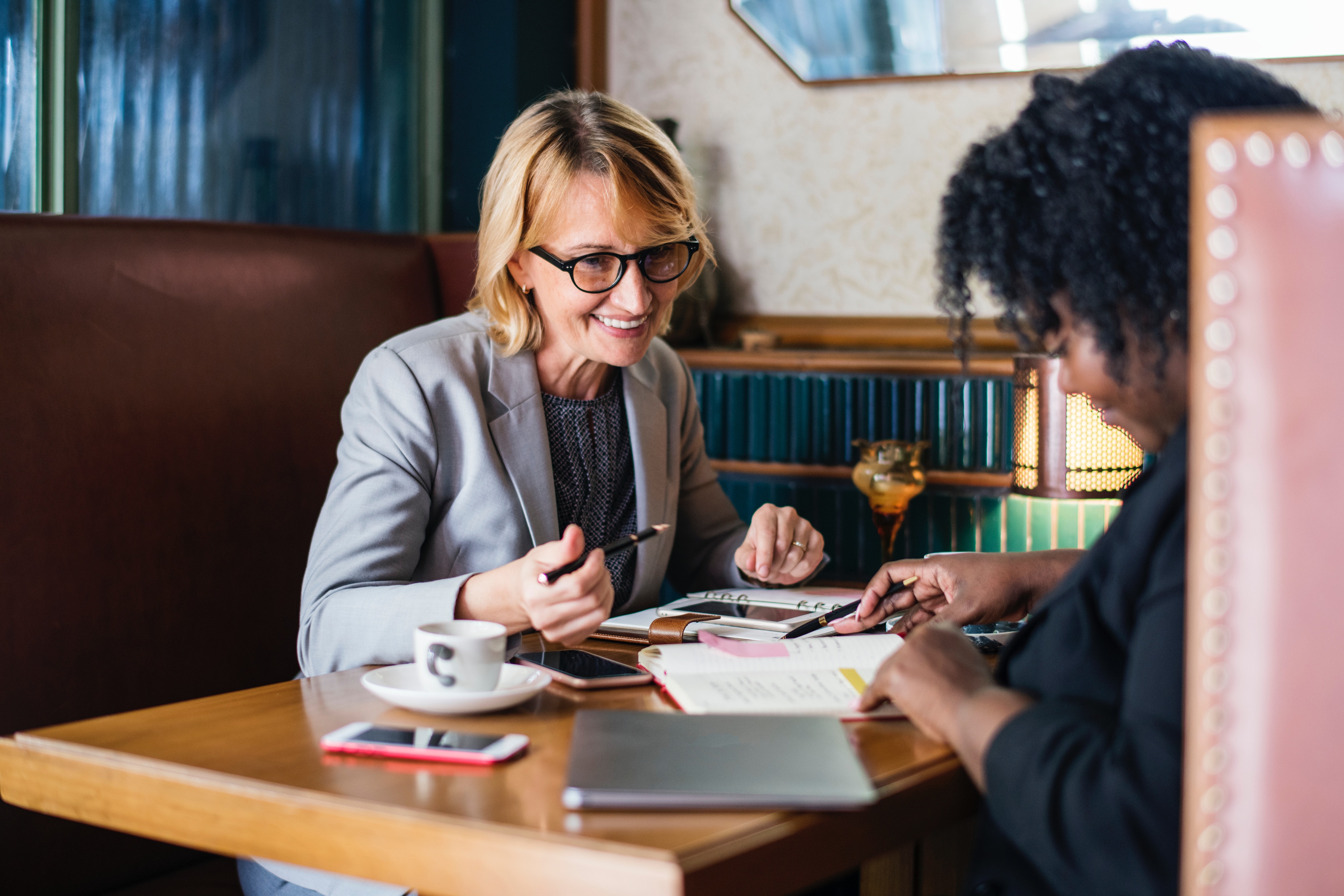 Woman mentoring woman over coffee