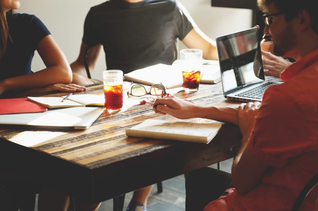 Employees sitting around table preparing strategic plan drinking coffee