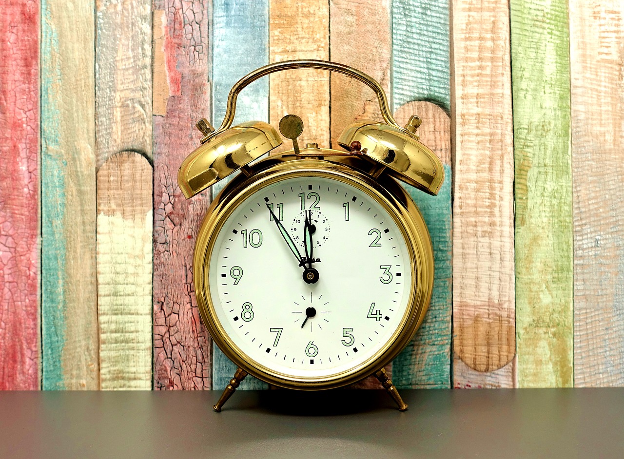 Gold alarm clock against wood wall