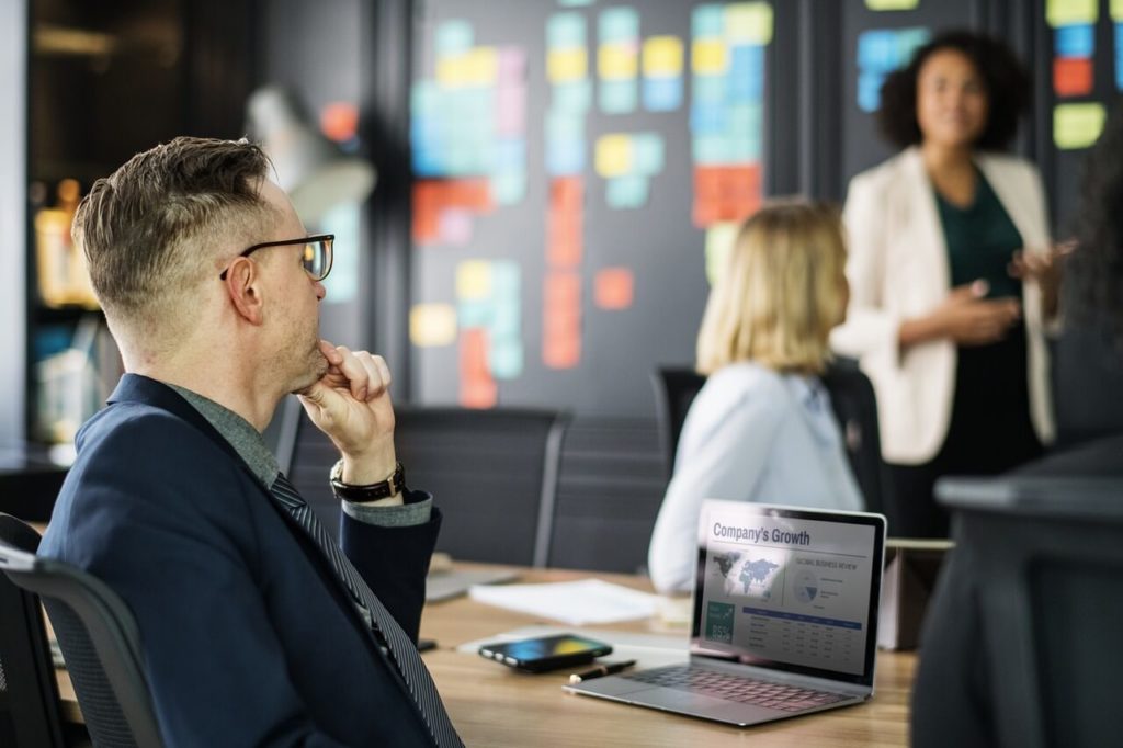 Male leader thinking about other careers while sitting in business meeting