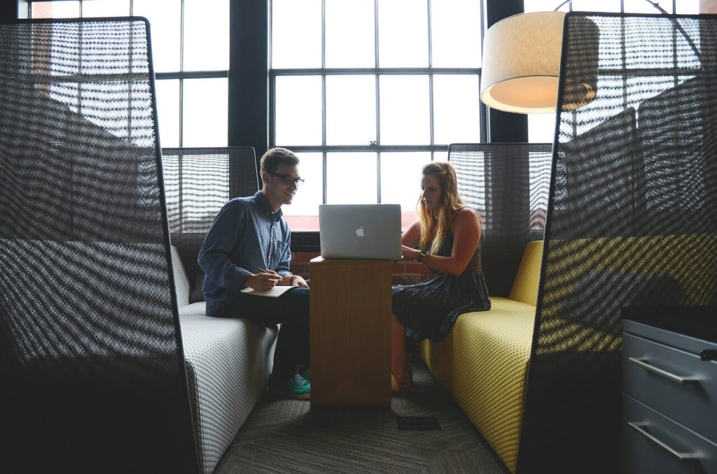 Two workers sharing a laptop