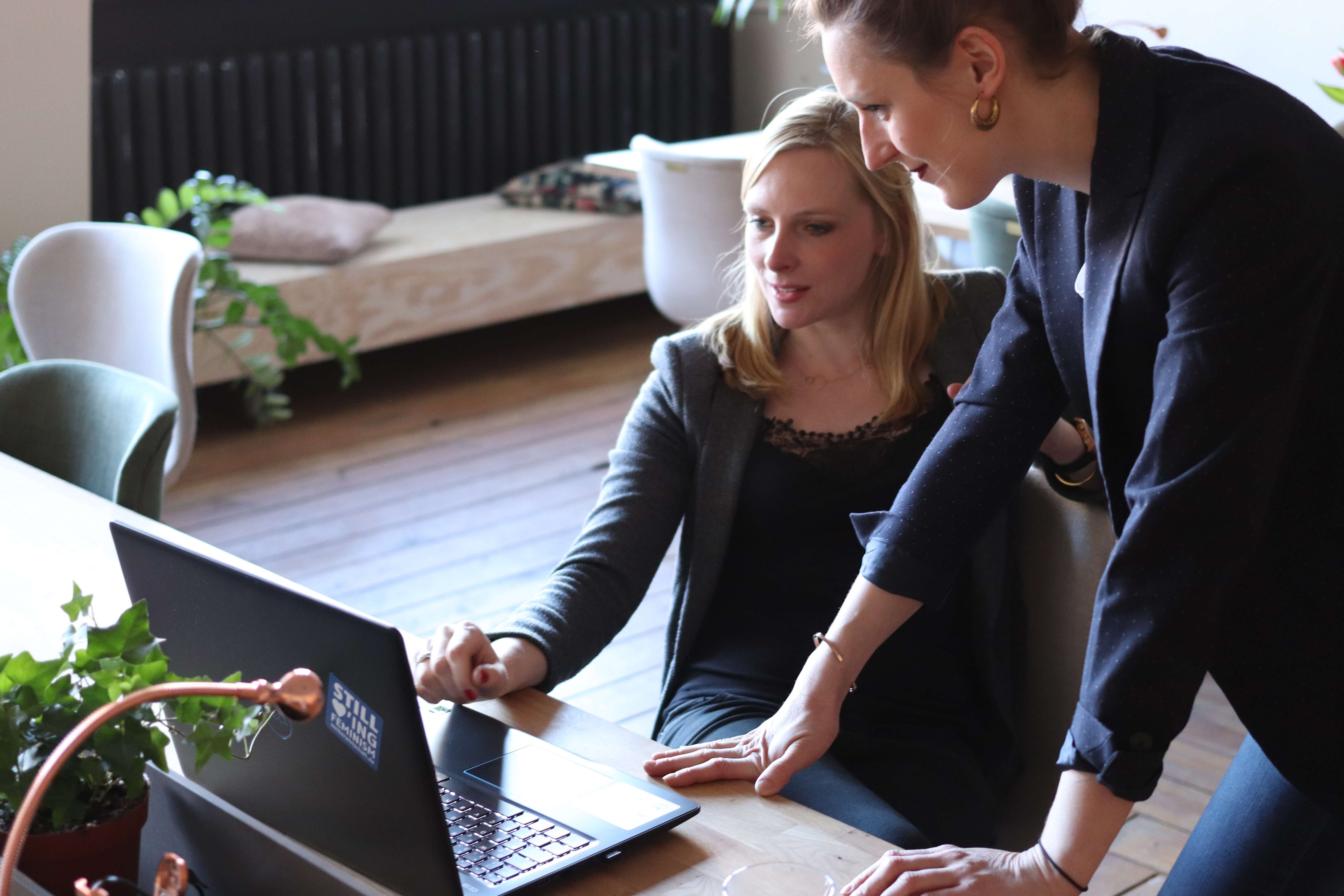 Woman sitting in front of black laptop