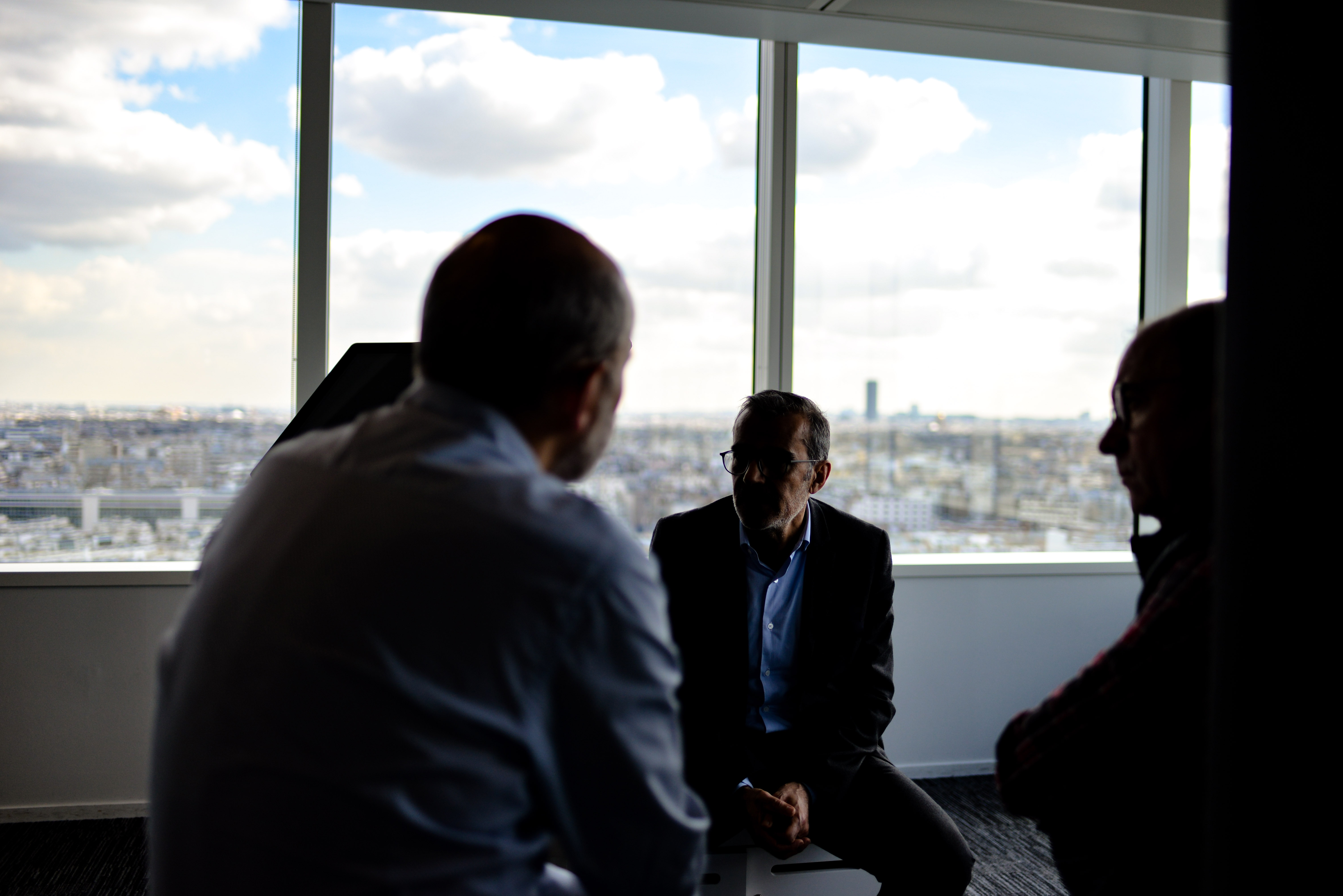 men sitting in circle talking in building