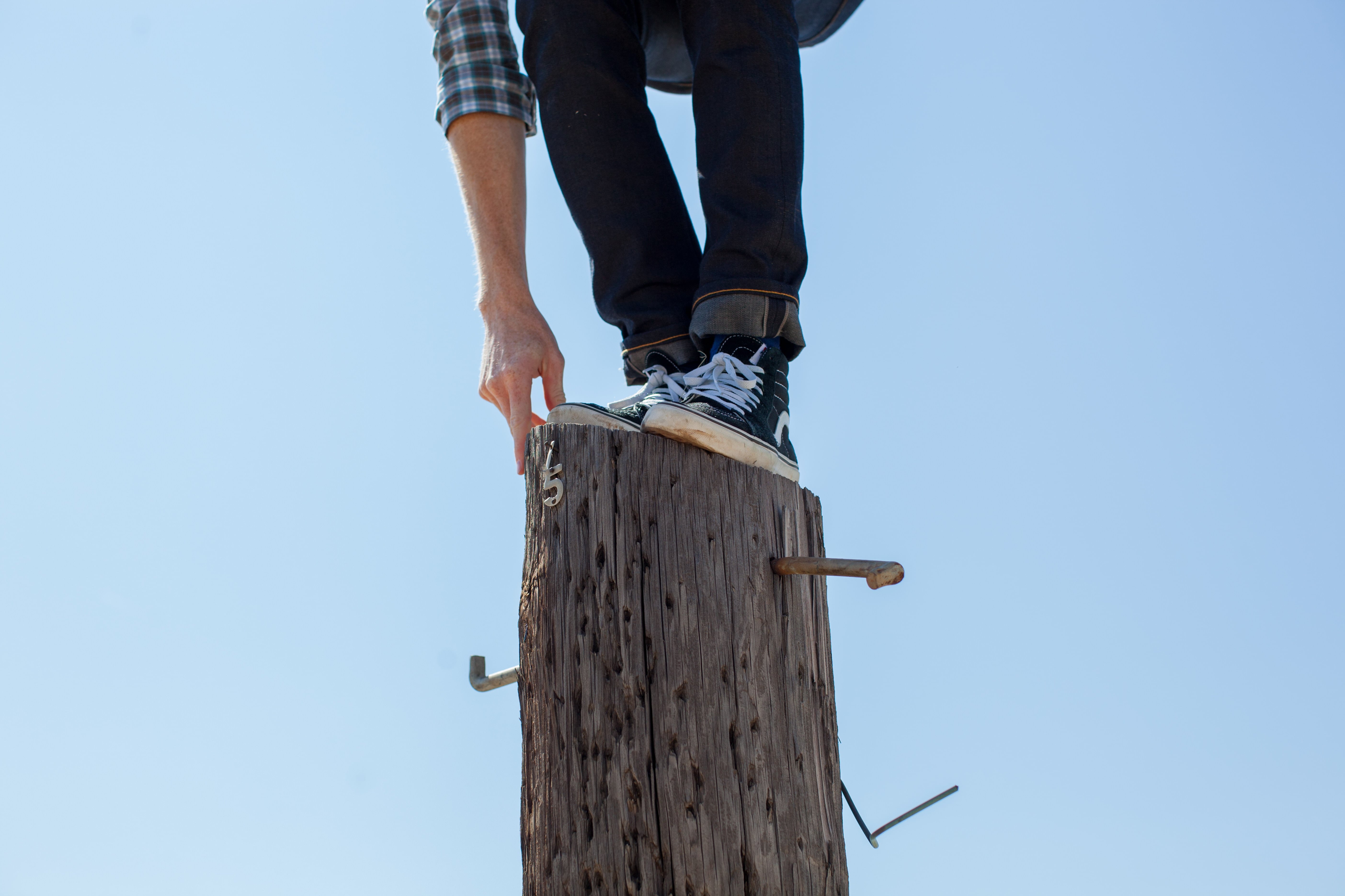 Man standing on high pole