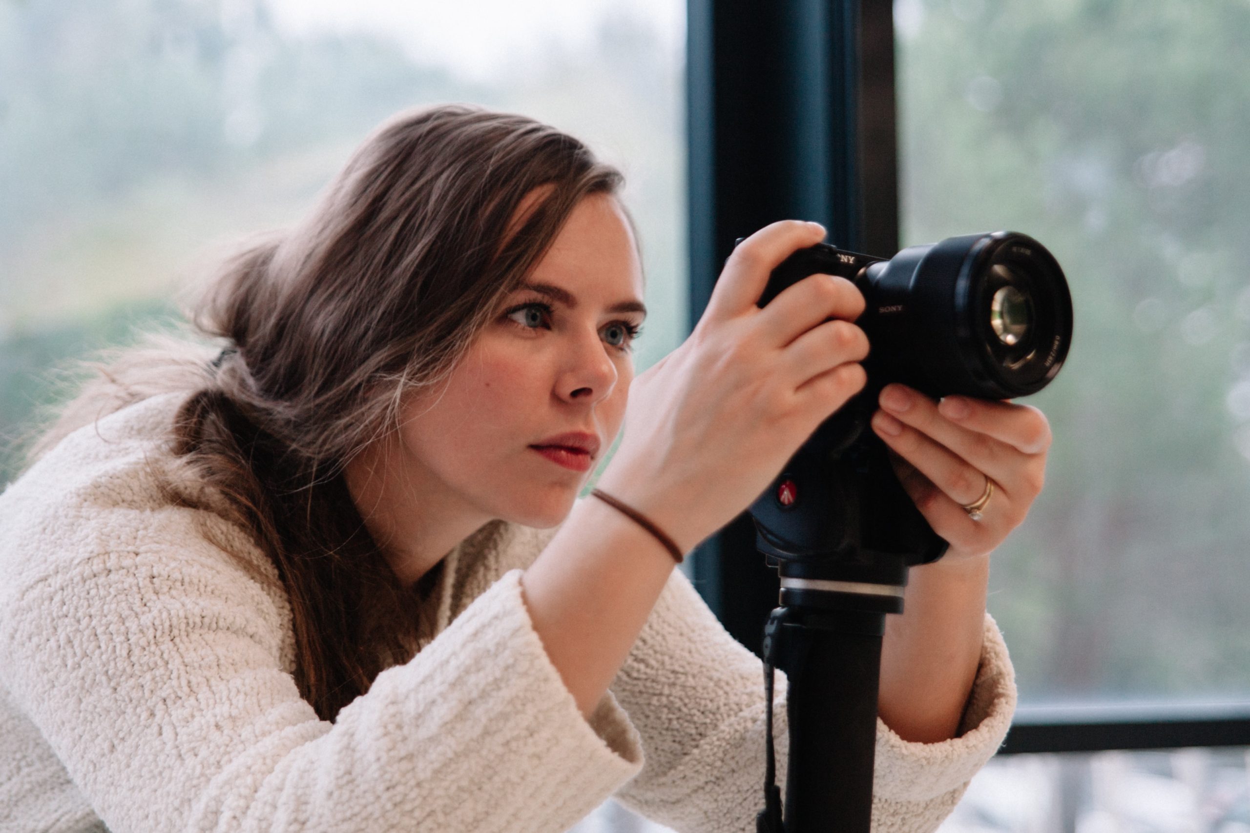 woman photographer setting up her camera on a tripod