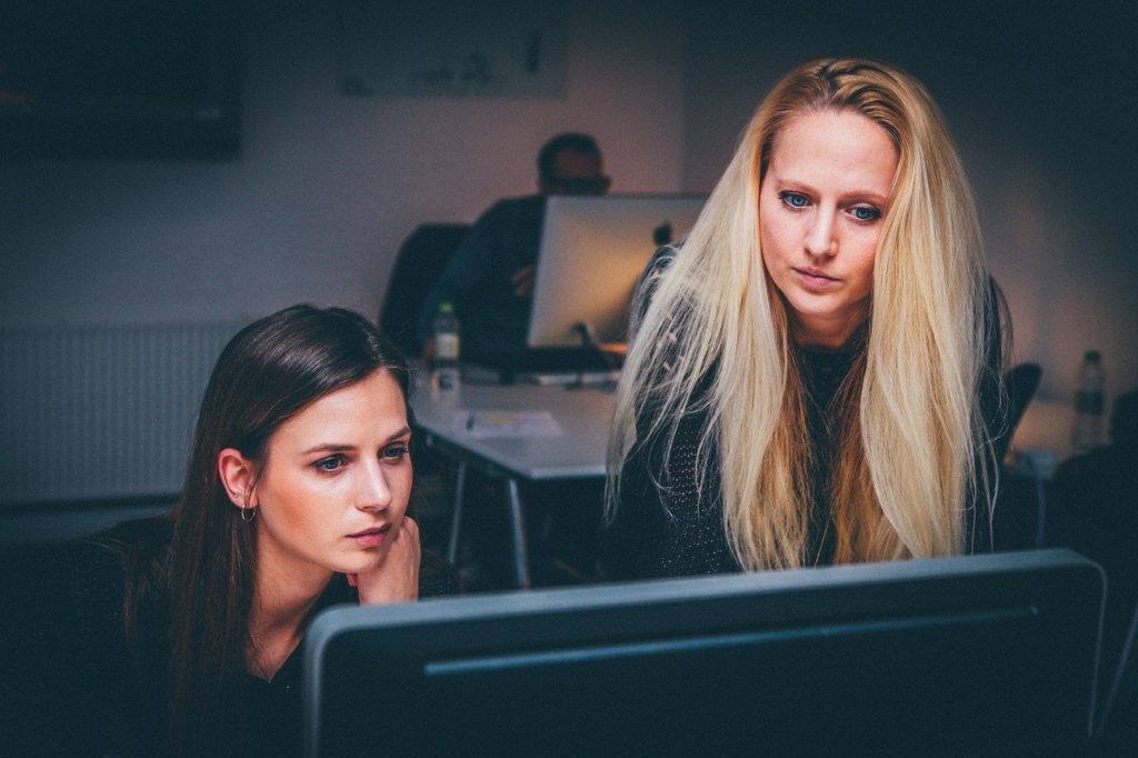 two women around a laptop